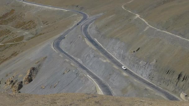 Cars drive along a winding road leading across the breathtaking Tibetan Pass. — Stock Video