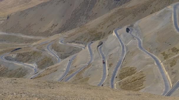 I veicoli guidano lungo una strada a serpentina che attraversa il passo tibetano mozzafiato . — Video Stock