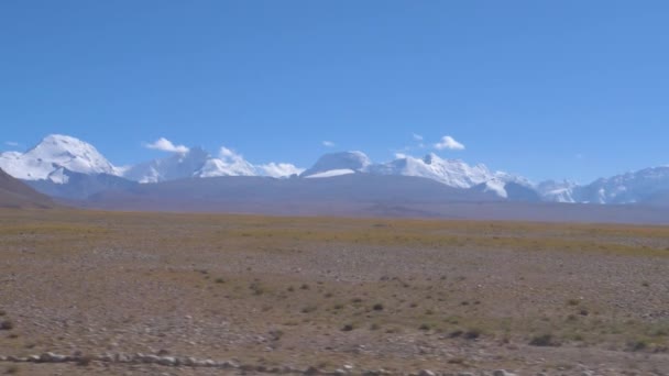 Neúrodné pláně vedou k úpatí zasněženého pohoří v Himálajích. — Stock video