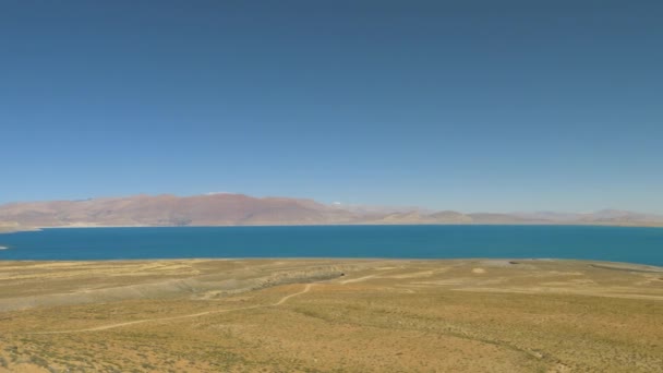 AÉRIEN : Vue panoramique sur le magnifique lac Paiku Co et la chaîne de montagnes lointaine — Video