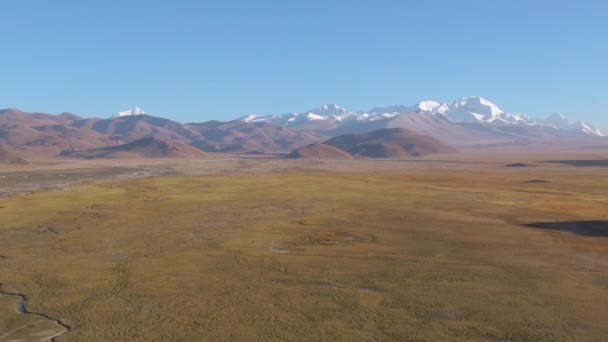 DRONE: Volando attraverso le pianure aride e verso la catena montuosa innevata . — Video Stock