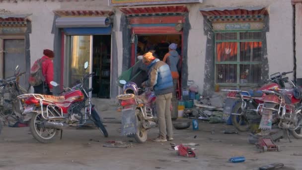 Homens locais se reúnem em frente a uma oficina de reparo de moto no centro da cidade de Ganggazhen . — Vídeo de Stock