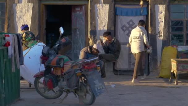 가까이 다가가 다: 현지의 티베트 인 남자들 이 집 옆에 앉아 핸드폰을 보고 있다. — 비디오
