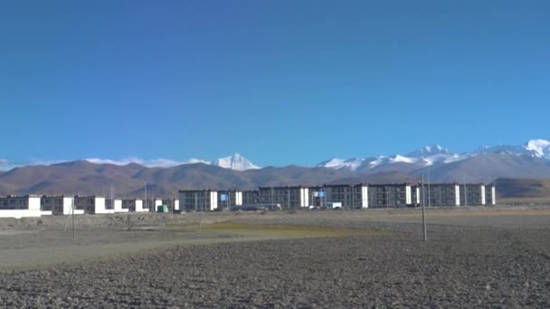 SLOW MOTION: Spektakularne pasmo śnieżnych gór z widokiem na małe miasto tybetańskie — Wideo stockowe
