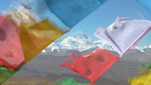 FECHAR-SE: Vista deslumbrante do Everest atrás de bandeiras de oração embaçadas agitando-se no vento — Vídeo de Stock