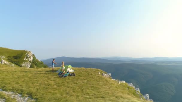 AERIAL: Aktiva unga par förbereder ett tält och deras camping tillsammans. — Stockvideo