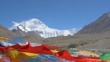 Karlı Everest 'in önünde dalgalanan Budist bayraklarının sinematik çekimi