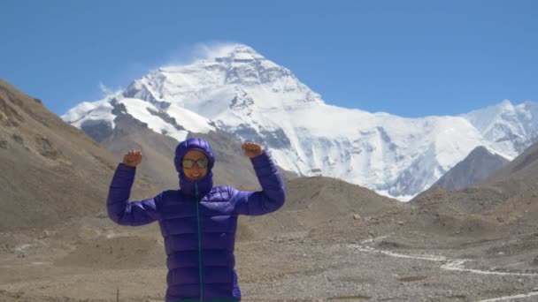 PORTRAIT Mujer alegre extiende sus brazos mientras está de pie frente al Everest — Vídeo de stock