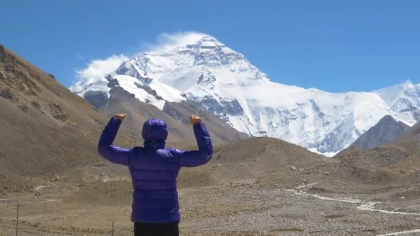 SLOW MOTION Trekker vítězoslavně rozpřahuje ruce při pozorování Mount Everest — Stock video