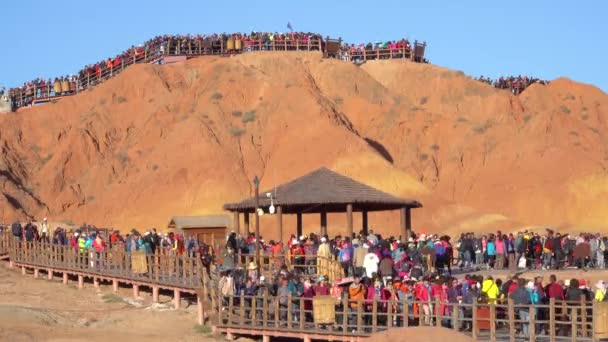 Countless travelers try to get to top of a hill to observe the rainbow mountains — Stock Video