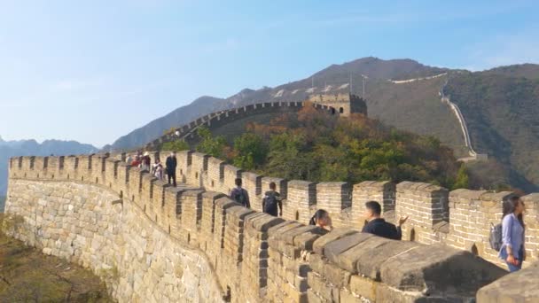 Los turistas caminan a lo largo de la antigua Gran Muralla de China en un día soleado de otoño. — Vídeos de Stock