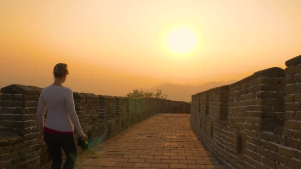 FLARE DE LA LENTE: La mujer camina a lo largo de la Gran Muralla China en una hermosa noche . — Vídeos de Stock