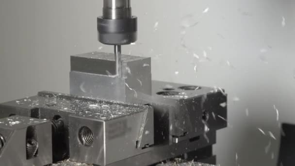 FERMER : De minuscules copeaux s'envolent d'un petit cube métallique traité par un outil de tour 