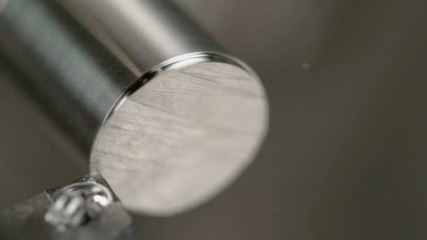 MACRO: Detailaufnahme eines Drehwerkzeugs, das die Kante einer glänzenden Metallstange rasiert. — Stockvideo
