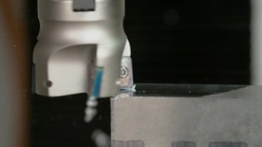 Otomatik CNC torna makinesi küçük bir çelik bloğu kesiyor..