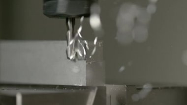 Keskin uçlu değirmen, küçük bir alüminyum işçiliğinin kenarlarını tıraş eder..