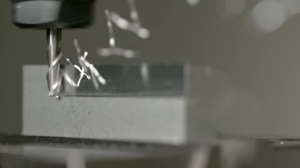 MACRO, DOF: Pedaços de metal torcidos voam de um bloco de alumínio durante o torneamento — Vídeo de Stock