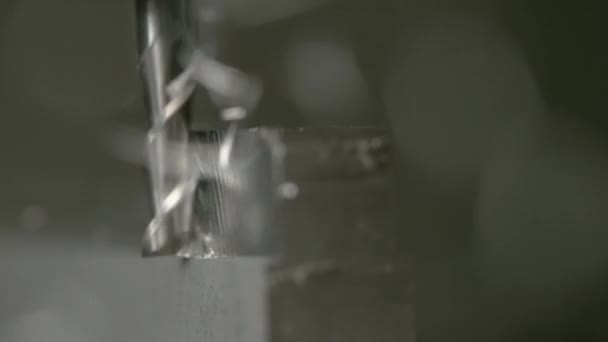 MACRO: Detailaufnahme eines feinen Schaftfräsers beim Rasieren der Seite eines matten Metallblocks. — Stockvideo