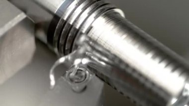 Keskin bıçak, parlak metal bir iş parçasının yan tarafında derin bir oyuk açar..