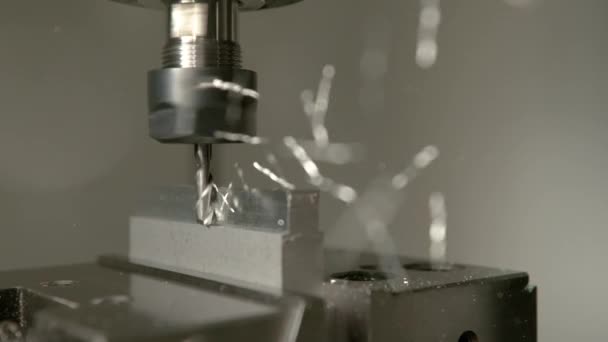 MACRO: Glanzende metaalspaanders vliegen van een werkstuk tijdens het frezen. — Stockvideo