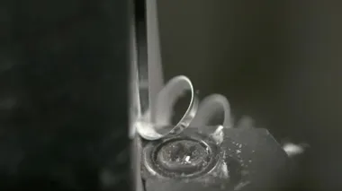 MACRO Keskin kenar bir metal bloğu keser ve bükülmüş bir traş oluşturur