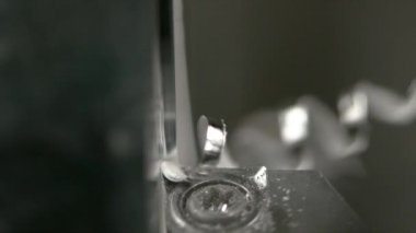 Aşırıya kaçan çeliğin kıvrımlı parçaları iplik bağlarken bir iş parçasından çıkar.