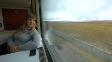 Bir tren yolculuğu sırasında Himalayalar 'ın manzarasını gözlemleyen kadın gezgin..