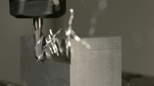 MACRO: trucioli di metallo in eccesso volano via da un pezzo durante la fresatura finale — Video Stock
