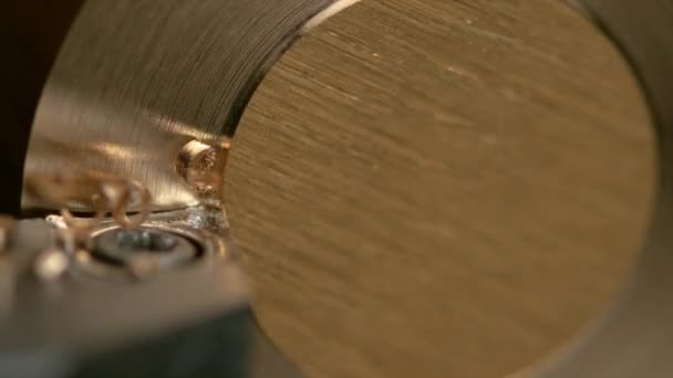 MACRO: herramienta de torneado agudo crea virutas mientras se corta en un cilindro de latón . — Vídeos de Stock