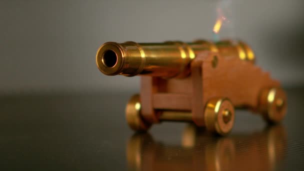 MACRO: Unrecognizable person lights up a loaded toy brass cannon with a match — Stock Video
