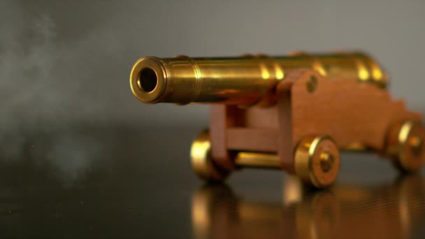 MACRO, DOF: Vintage mosiężne zabawki armata strzela małą kulę armatnią w poprzek pokoju. — Wideo stockowe