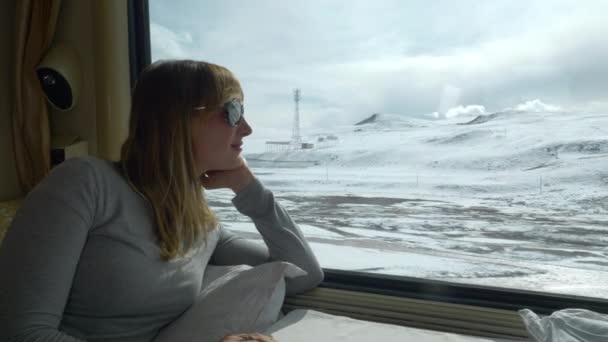 Κοντινό πλάνο: Νεαρή γυναίκα παρατηρεί το γραφικό χιονισμένο Ιμαλάια κατά τη διάρκεια μιας διαδρομής με το τρένο. — Αρχείο Βίντεο
