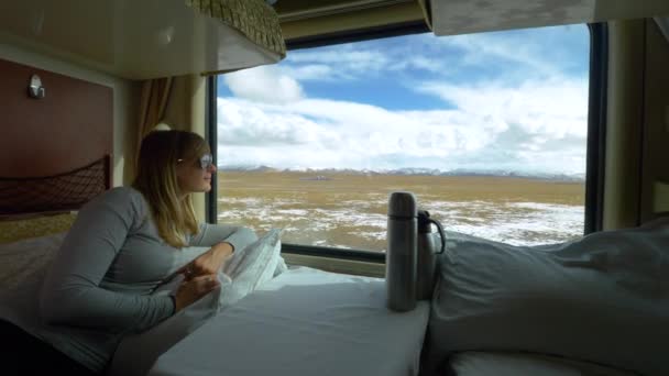 FERMER : Femme blanche joyeuse regarde par la fenêtre de sa cabine de première classe — Video