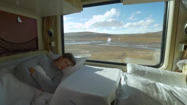 CLOSE UP: Tired girl sleeps in her sleeper cabin during train ride across Tibet. — Stock Video