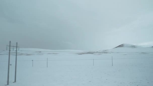 Rijdend in een trein langs elektriciteitsleidingen over de besneeuwde vlaktes in Tibet — Stockvideo