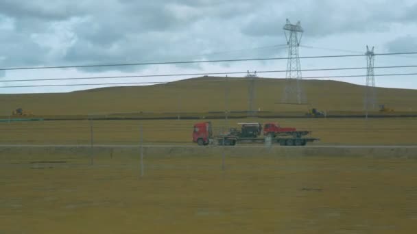 Stromkabel versperren die Sicht auf einen LKW, der durch die tibetische Ebene fährt — Stockvideo