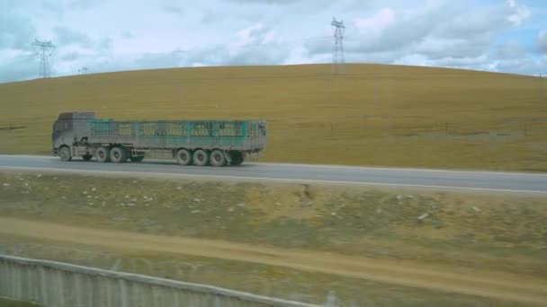 Treno lungo un grande camion con un rimorchio vuoto per il trasporto del bestiame. — Video Stock