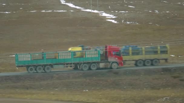 Vecchio camion rosso con rimorchio vuoto per il trasporto di bestiame guida lungo la strada panoramica — Video Stock