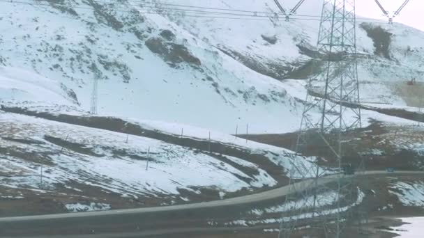SLOW MOTION: Lastkraftwagen fährt eine Landstraße entlang, die an verschneiten Bergen vorbeiführt. — Stockvideo