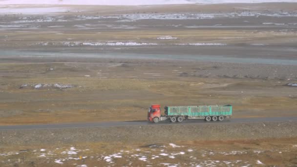 Lassú MOZGÁS Piros teherautó egy üres pótkocsi vezet végig a hegyi patak — Stock videók
