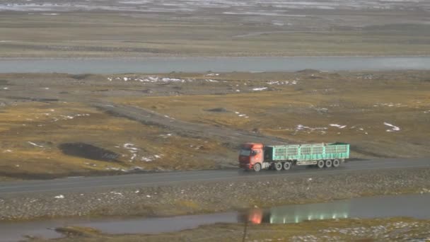 Lassú MOZDÁS: Piros teherautó üres pótkocsi hajtások mentén hegyi patak — Stock videók