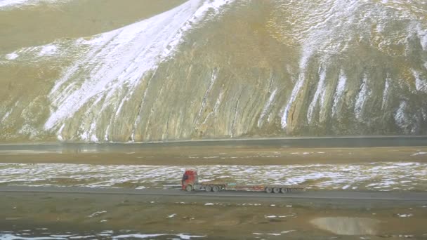 没有货物的货车沿着高耸的山下的河流行驶 — 图库视频影像