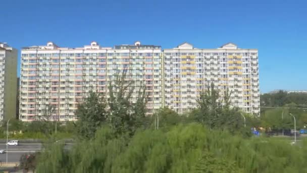 SLOW MOTION: Commuters drive along a highway leading past apartment buildings — Stock Video