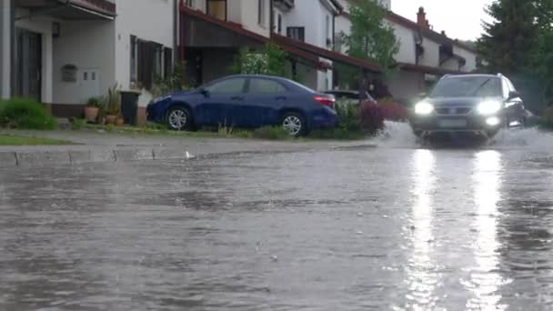 SUV banliyölerden geçerken kameraya yağmur suyu sıçratıyor. — Stok video