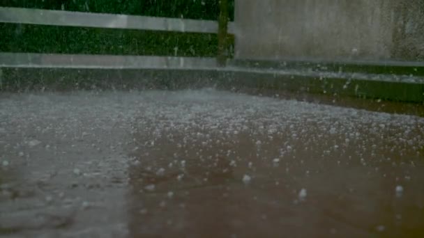 CERRAR, DOF: Granos de graupel y agua de lluvia cubren el balcón de baldosas marrones. — Vídeo de stock