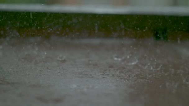 MACRO : Tempête de pluie printanière rafraîchissante qui lave le sol marron carrelé d'un porche. — Video