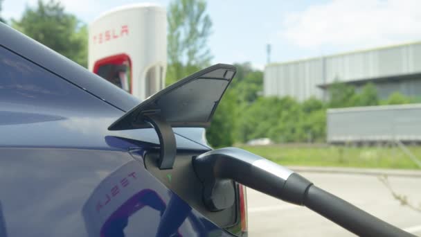 CERRAR: Tesla está conectado y llenando la batería en una estación de carga. — Vídeo de stock