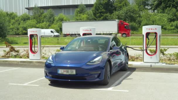 Lassú MOTION: félelmetes Tesla Model 3 újratölti az akkumulátort egy töltő terminál — Stock videók