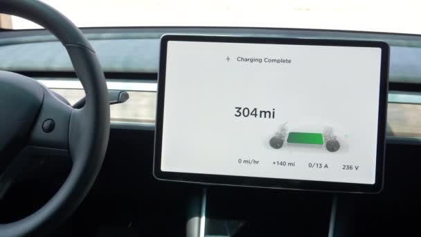 Bir Tesla 'nın içindeki dokunmatik ekran, arabanın aküsünün tamamen şarj olduğunu bildirir.. — Stok video