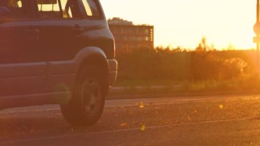 Eski SUV, güneşli bir sonbahar akşamında boş bir yolda gidiyor..